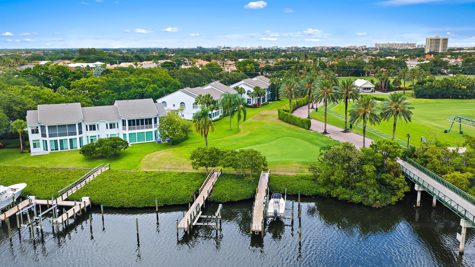 An aerial view shows waterfront townhomes with boat docks, a golf course, and palm trees — 316 Spyglass Way, Jupiter FL 33477, JUPITER, FL