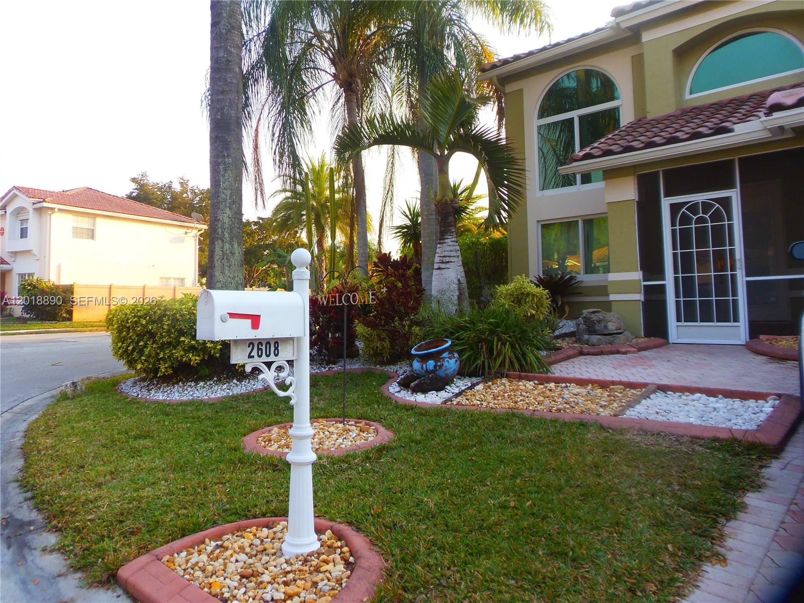 A white mailbox stands in the front yard of a house with palm trees — 2608 NW 79th Ave, Margate FL 33063, MARGATE, FL