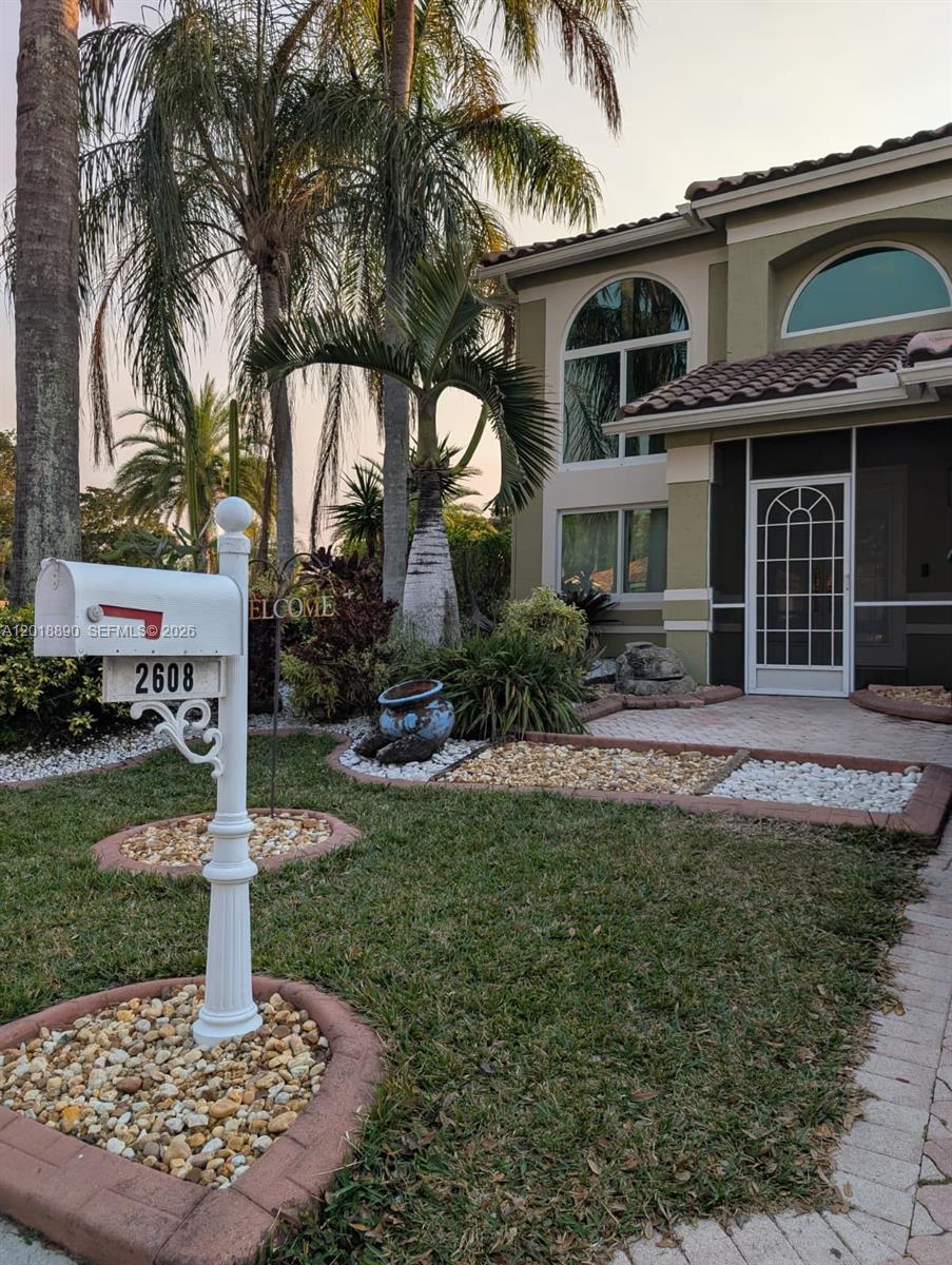 A white mailbox stands in the front yard of a two-story house with palm trees — 2608 NW 79th Ave, Margate FL 33063, MARGATE, FL