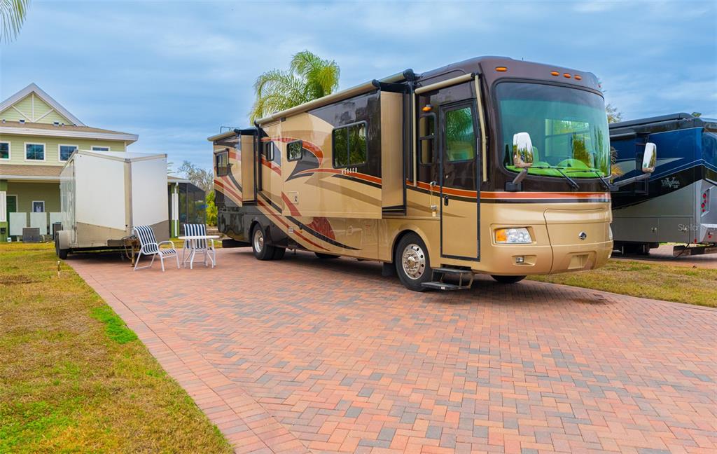 A large motorhome and a small trailer are parked on a paved driveway near a house — 6940 AMANDA VISTA CIRCLE, LAND O LAKES, FL