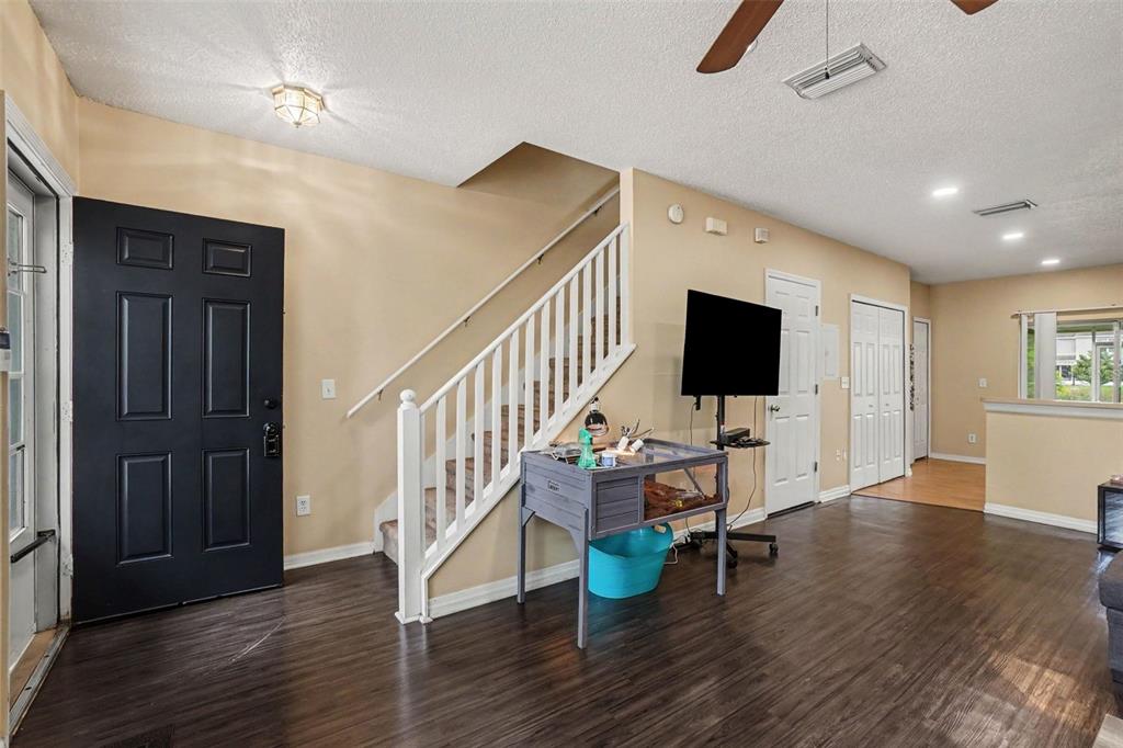 An entryway features a black front door, a staircase with white railings, and dark flooring — 6236 OSPREY LAKE CIRCLE, RIVERVIEW, FL