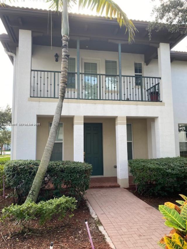 A two-story building exterior features a balcony with a metal railing and a front entrance — 11835 SW 27th St # 801, Miramar FL 33025, MIRAMAR, FL