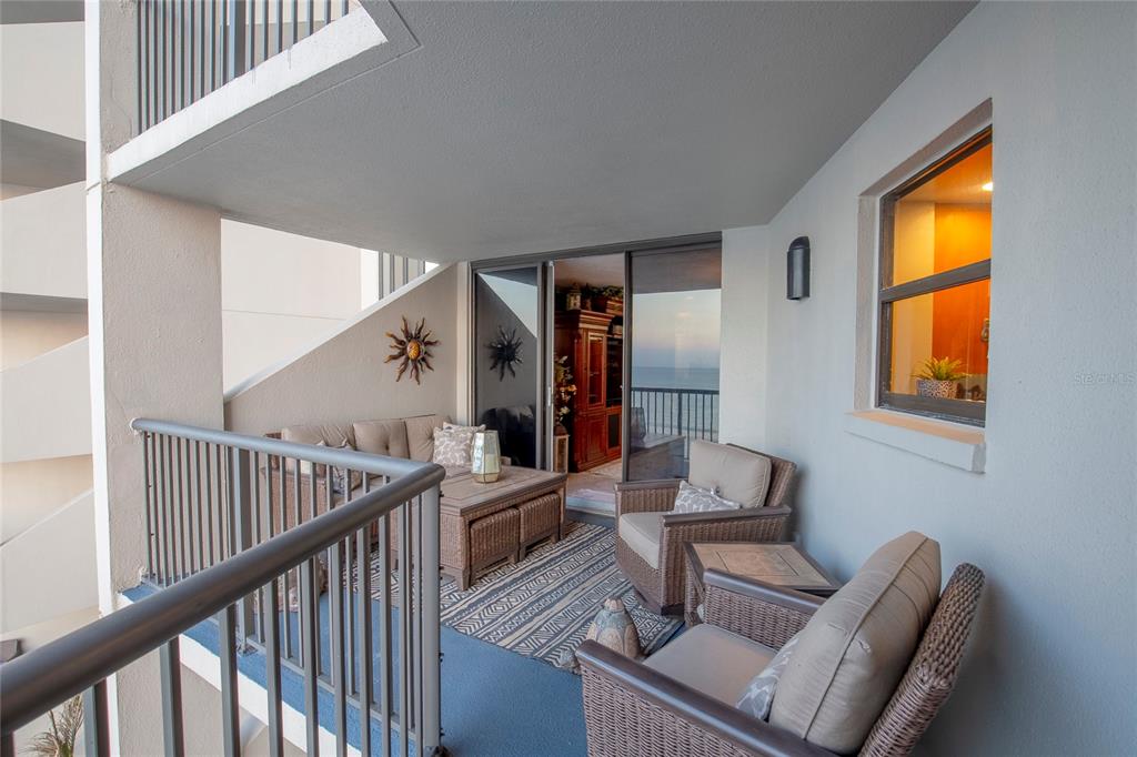 A living room with white marble floors, a crystal chandelier, and a view of the ocean — 1600 GULF BOULEVARD UNIT 512, CLEARWATER BEACH, FL