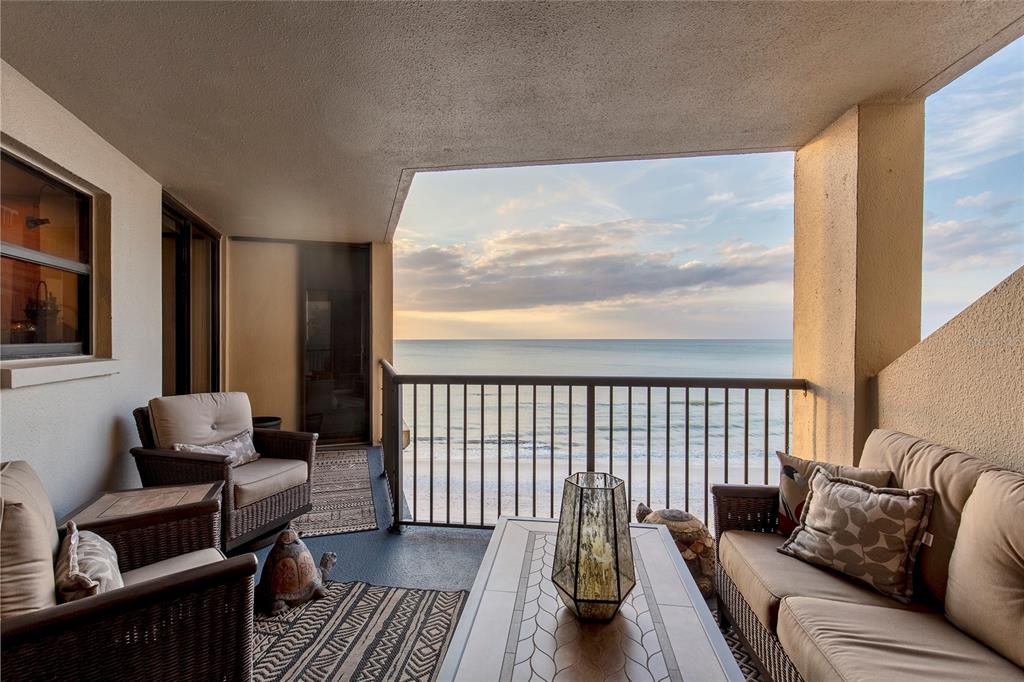 A bright living room features marble floors, a fireplace, mirrored walls, and a view of the ocean — 1600 GULF BOULEVARD UNIT 512, CLEARWATER BEACH, FL