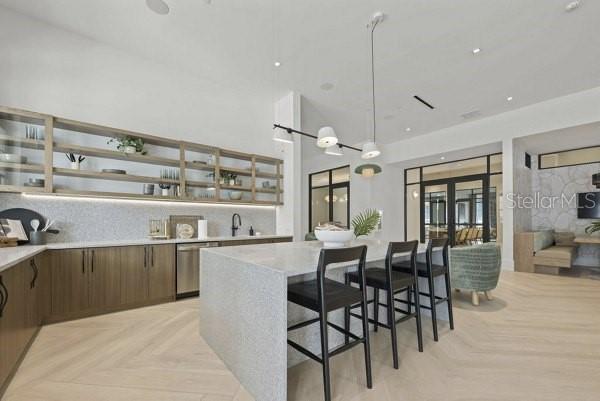 A modern kitchen features a large stone island with black stools and open wooden shelving — 2790 GRAND AVE STREET UNIT A2, ST PETERSBURG, FL