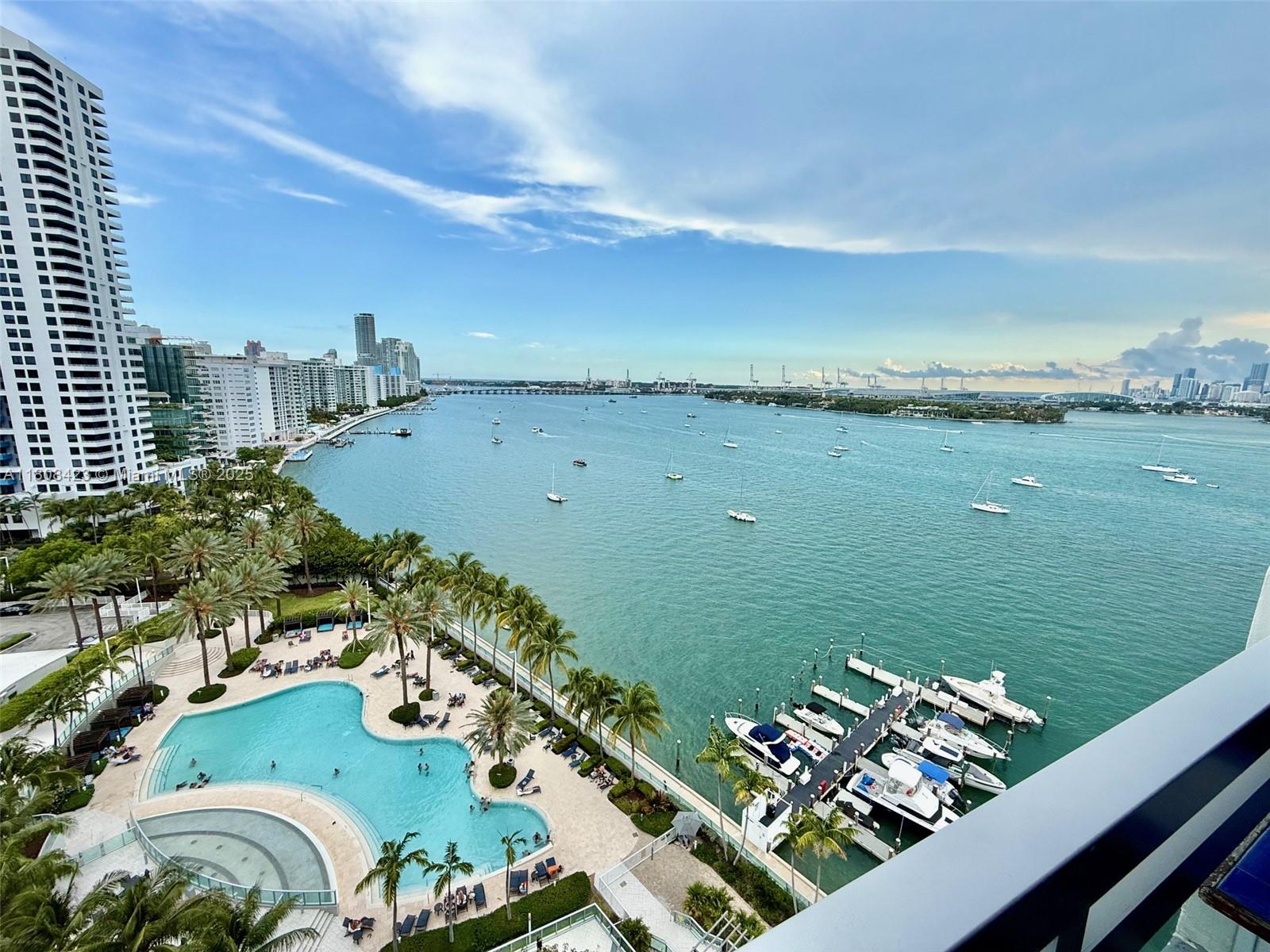 An elevated view of a swimming pool, boat docks, and a bay with many boats — 1500 Bay Rd # 1534S, Miami Beach FL 33139, MIAMI BEACH, FL