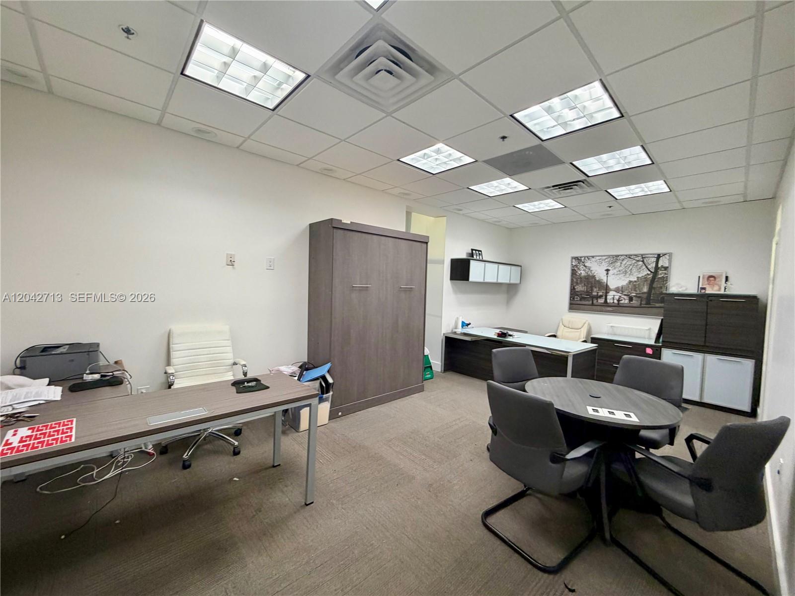 This office features a desk, a round meeting table with chairs, and a storage cabinet — 7500 NW 25th St # 205, Miami FL 33122, MIAMI, FL