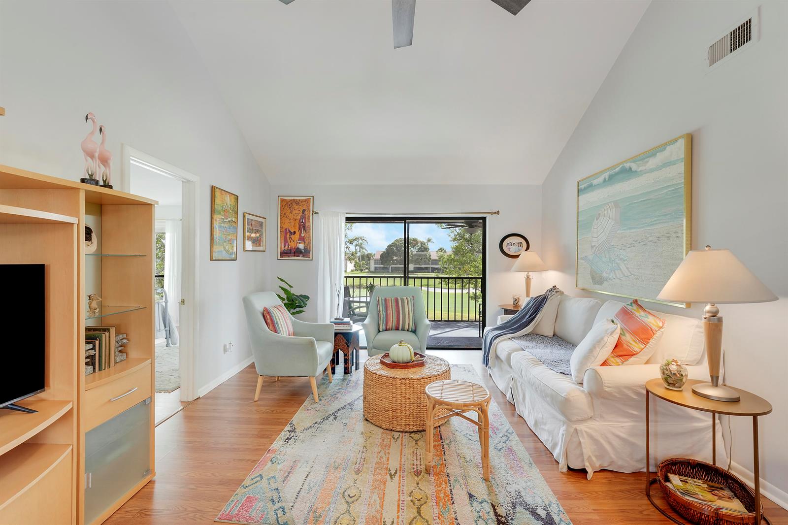 A living room with light blue armchairs, a white sofa, and a view of greenery — 402 Wingfoot Drive # B, Jupiter FL 33458, JUPITER, FL