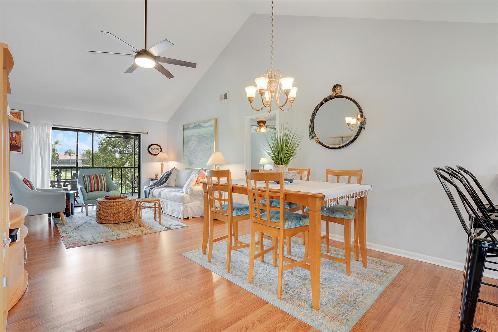 A dining area and living room with vaulted ceilings, wood flooring, and a balcony view — 402 Wingfoot Drive # B, Jupiter FL 33458, JUPITER, FL