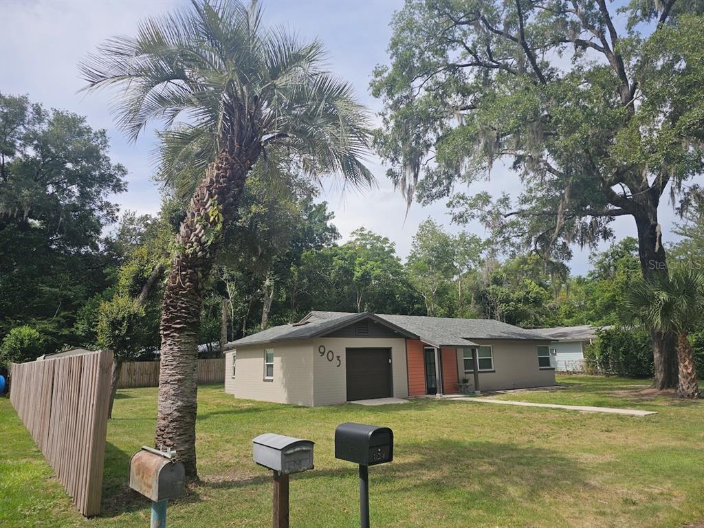 A single-story house with a garage, palm tree, and three mailboxes in the front yard — 903 NW 33RD AVENUE, GAINESVILLE, FL