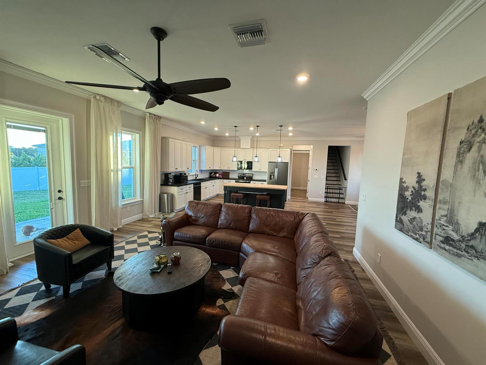 A living room with a leather sectional and round table opens into a white kitchen — 3533 Sky Valley Lane, Clewiston FL 33440, CLEWISTON, FL