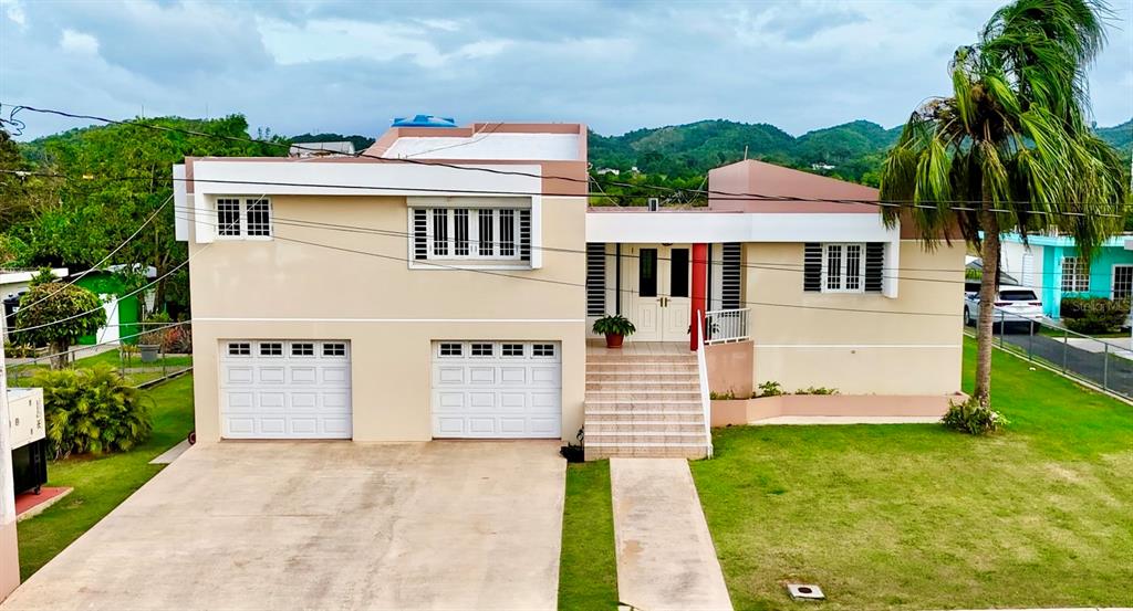 A two-story house with a beige exterior, two garage doors, and a front staircase — Urb. La Romana 216 CALLE FRANCHESCO, QUEBRADILLAS, PR