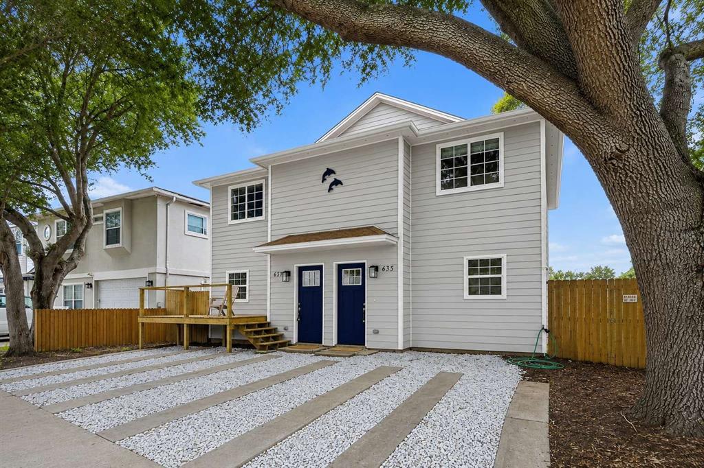 A two-story gray house with two blue front doors and a gravel driveway — 635 6TH AVENUE S, JACKSONVILLE BEACH, FL