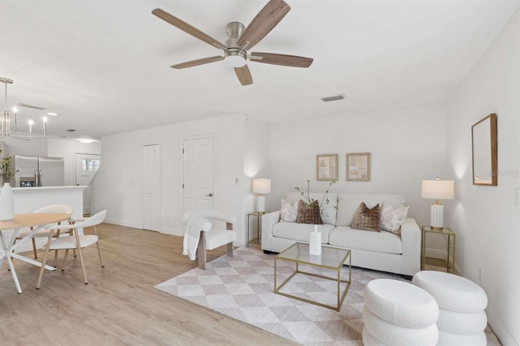 A living room with a white sofa, a ceiling fan, and light wood flooring — 635 6TH AVENUE S, JACKSONVILLE BEACH, FL