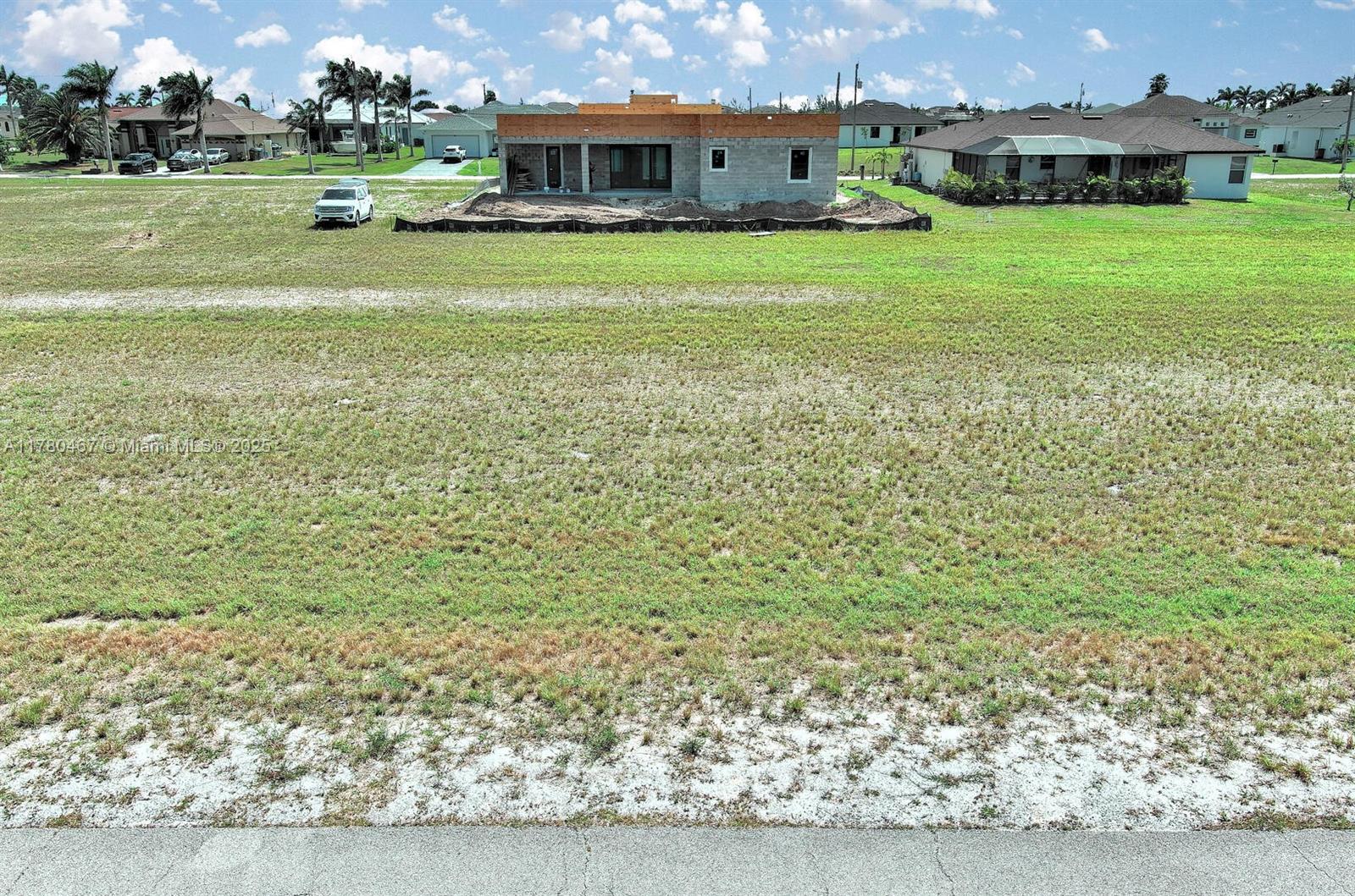 An exterior view of a residential construction site featuring a partially built house on a lot — 1037 NW 37TH PL, Cape Coral FL 33993, CAPE CORAL, FL