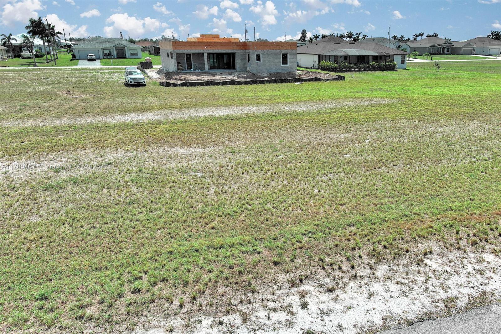 An aerial view shows a house under construction on a large, grassy lot — 1037 NW 37TH PL, Cape Coral FL 33993, CAPE CORAL, FL