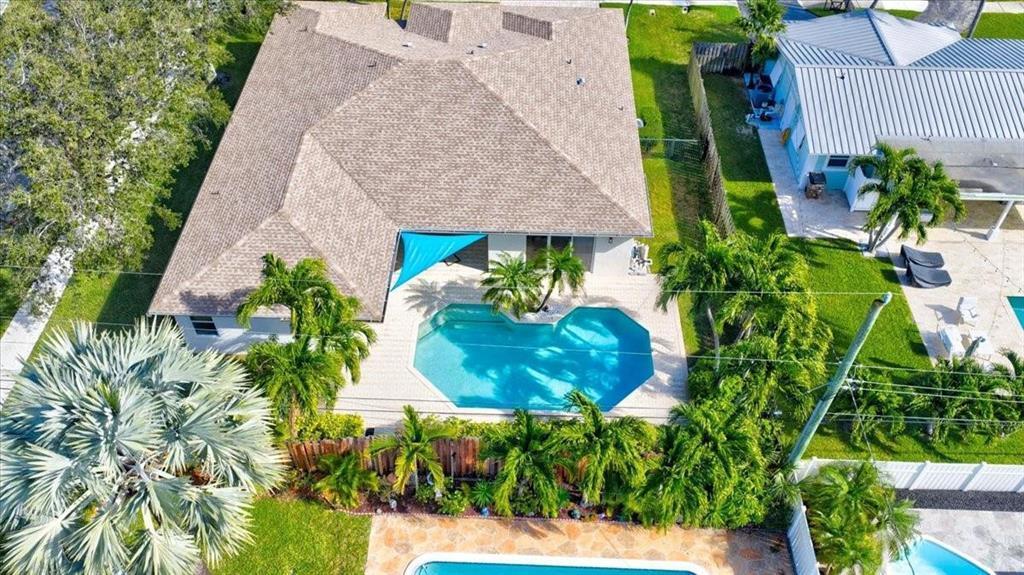 An aerial view shows a house with a shingled roof, a swimming pool, and landscaping — 517 SE 7TH Avenue, Deerfield Beach FL 33441, DEERFIELD BEACH, FL