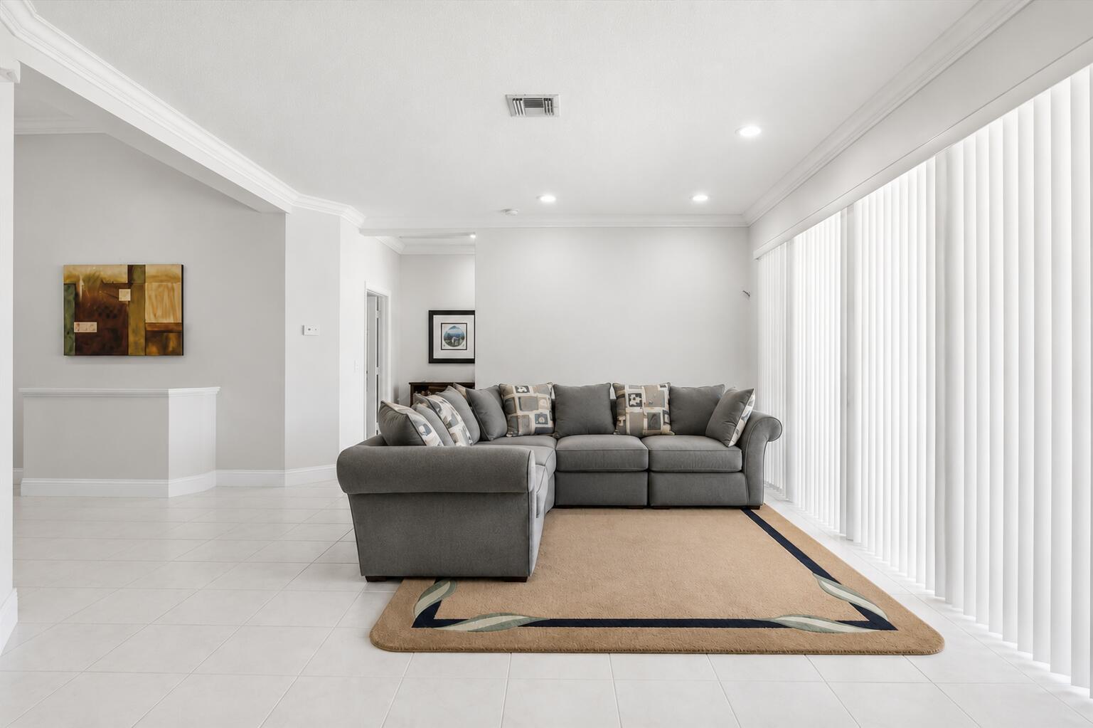 A living room features a grey sectional sofa on a tan rug over tile floors — 517 SE 7TH Avenue, Deerfield Beach FL 33441, DEERFIELD BEACH, FL