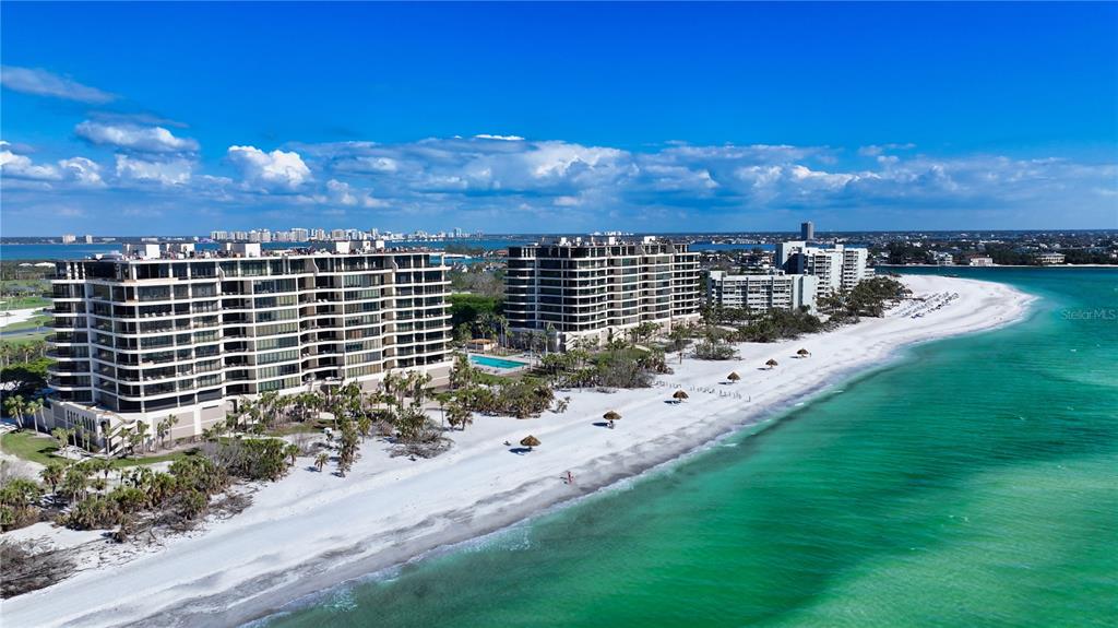 An aerial view of two large beachfront condominium buildings along a white sand beach — 435 L AMBIANCE DRIVE UNIT L807, LONGBOAT KEY, FL