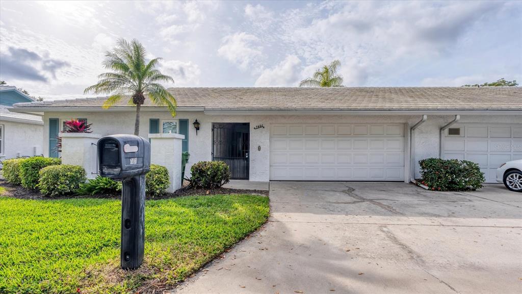 A single-story white house with a two-car garage and a front lawn — 7401 7TH AVENUE W UNIT 5807, BRADENTON, FL
