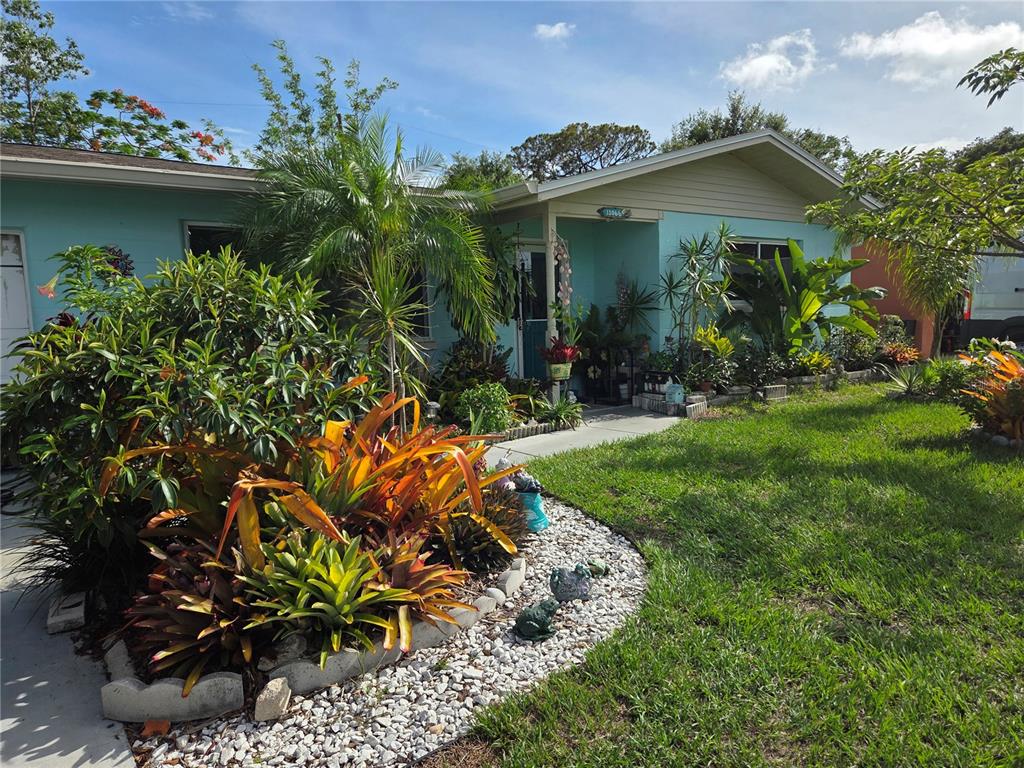 A light blue house with a landscaped front yard and a white rock garden bed — 11066 102ND AVENUE N, SEMINOLE, FL