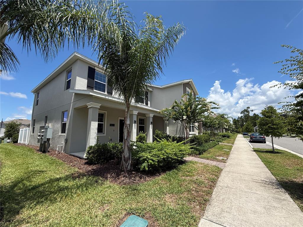 A two-story house with a palm tree in the front yard and a sidewalk nearby — 5647 QUIET PALM LOOP, ST CLOUD, FL