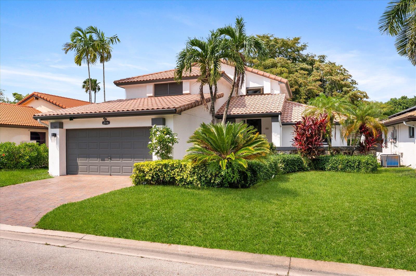 A two-story house with a tile roof, a gray garage door, and a landscaped front yard — 2116 Austin, Weston FL 33326, WESTON, FL