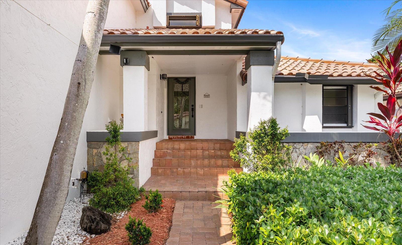 The front entrance of a house features a brick walkway, steps, and a glass door — 2116 Austin, Weston FL 33326, WESTON, FL