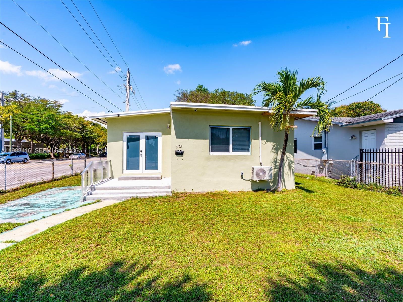 A light green single-story house features a front porch, double glass doors, and a palm tree — 1195 NW 48th St, Miami FL 33127, MIAMI, FL