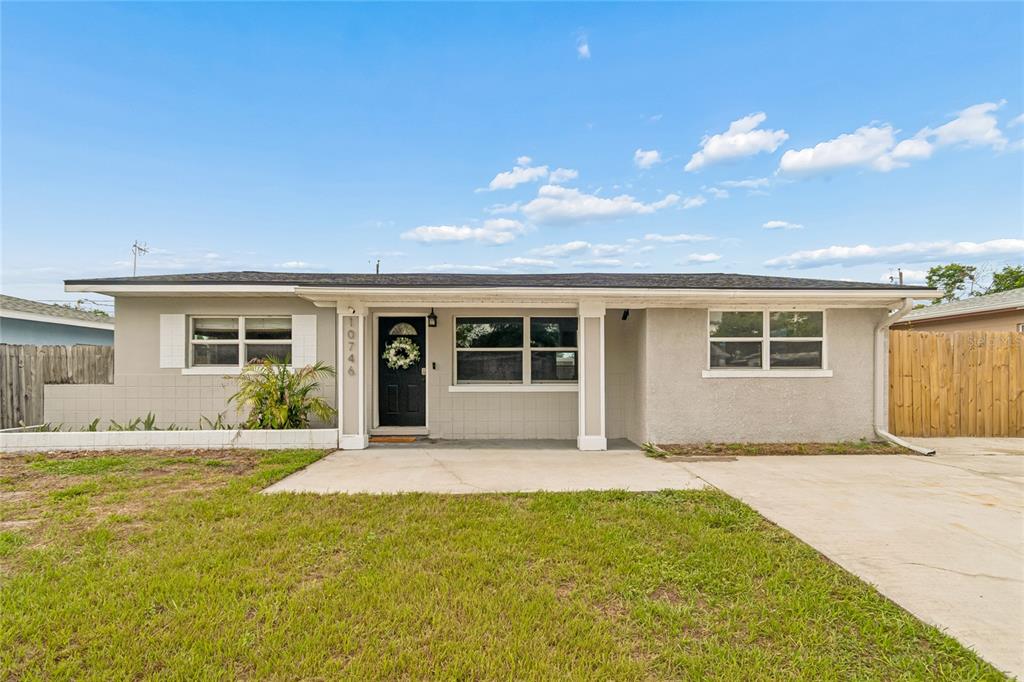 A single-story house with a gray exterior, a front porch, and a concrete driveway — 10746 109TH STREET, SEMINOLE, FL