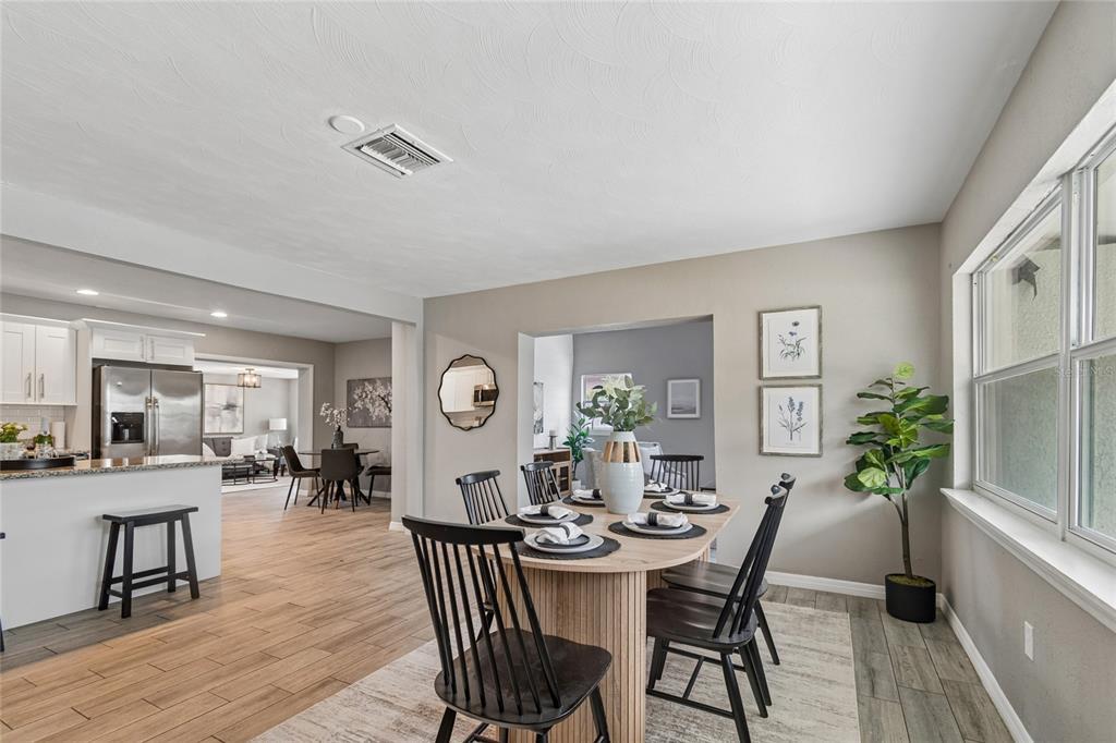A dining area with a wooden table and black chairs sits near a kitchen — 10746 109TH STREET, SEMINOLE, FL