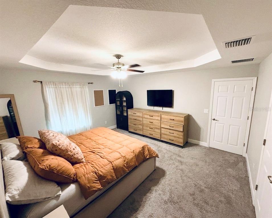 A living room features a gray sectional sofa, a fireplace with a television, and tile flooring — 5601 SW 117TH LANE ROAD, OCALA, FL