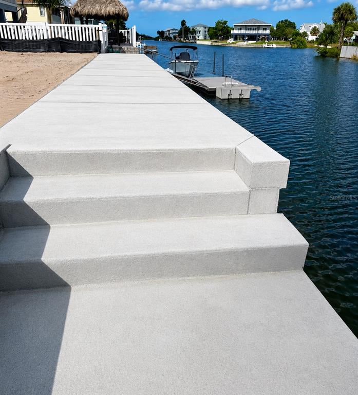 A concrete walkway with steps leads to a boat dock on a canal — 3511 AMBERJACK DRIVE, HERNANDO BEACH, FL