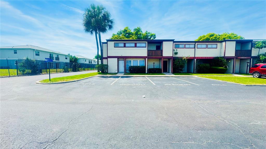 A two-story apartment building with a parking lot in the foreground — 4016 WOODFERN DRIVE UNIT B8, ORLANDO, FL