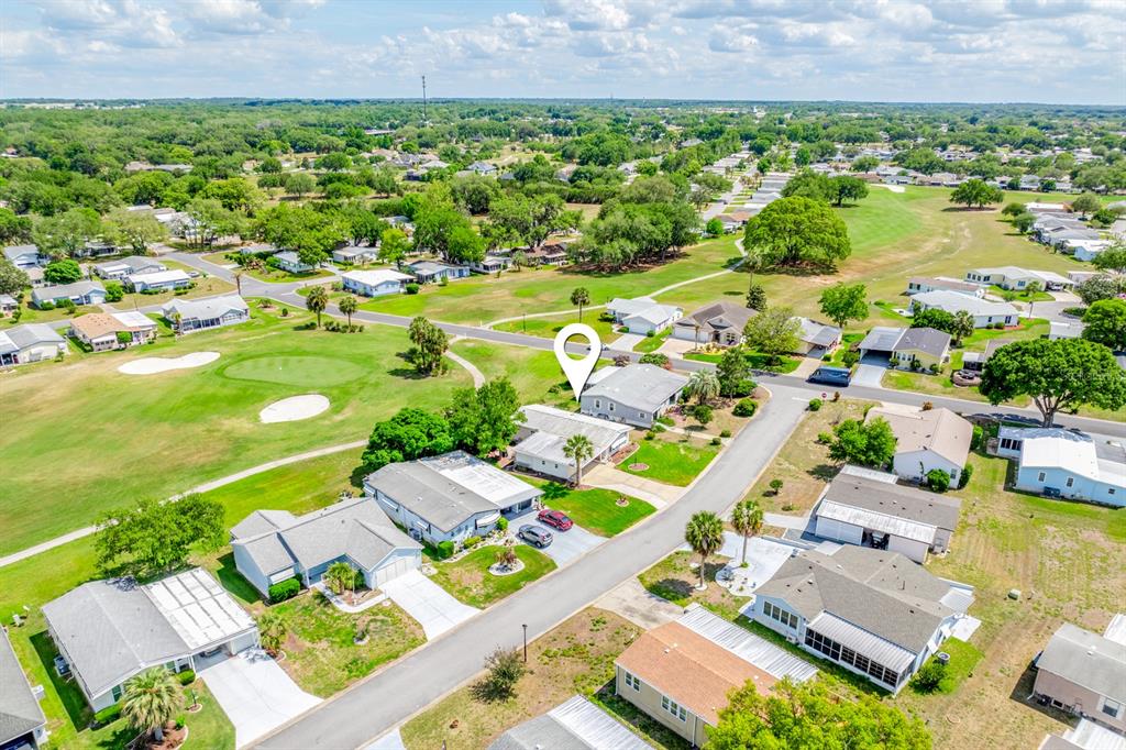 An aerial view shows a residential neighborhood with houses situated along a golf course — 1603 COG HILL DRIVE, LADY LAKE, FL
