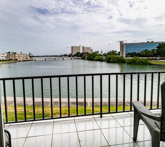 A balcony with a tiled floor and black railing overlooks a body of water and buildings — 7401 BAY ISLAND DRIVE S UNIT 237, SOUTH PASADENA, FL