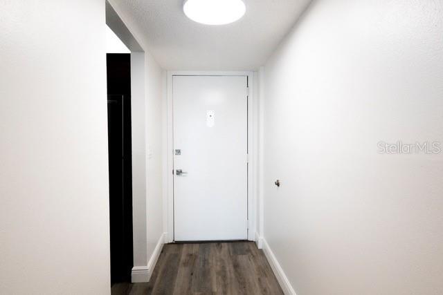 A white door stands at the end of a hallway with wood-look flooring — 7401 BAY ISLAND DRIVE S UNIT 237, SOUTH PASADENA, FL