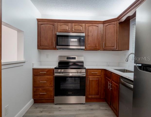 A kitchen features wood cabinets, stainless steel appliances, and light-colored countertops — 7401 BAY ISLAND DRIVE S UNIT 237, SOUTH PASADENA, FL