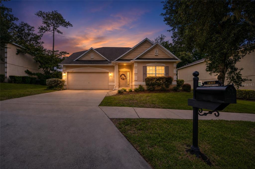 A single-story suburban house with a two-car garage and a mailbox in the foreground — 14369 NW 159TH PLACE, ALACHUA, FL