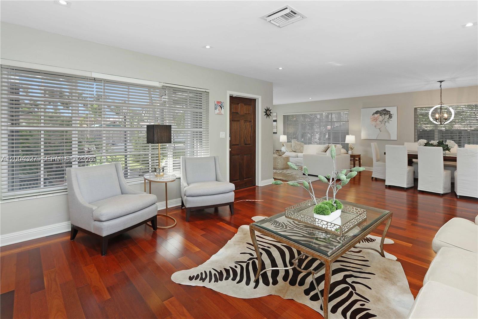 A living room features hardwood floors, a zebra-print rug, and a glass-topped coffee table — 1147 Buchanan St, Hollywood FL 33019, HOLLYWOOD, FL