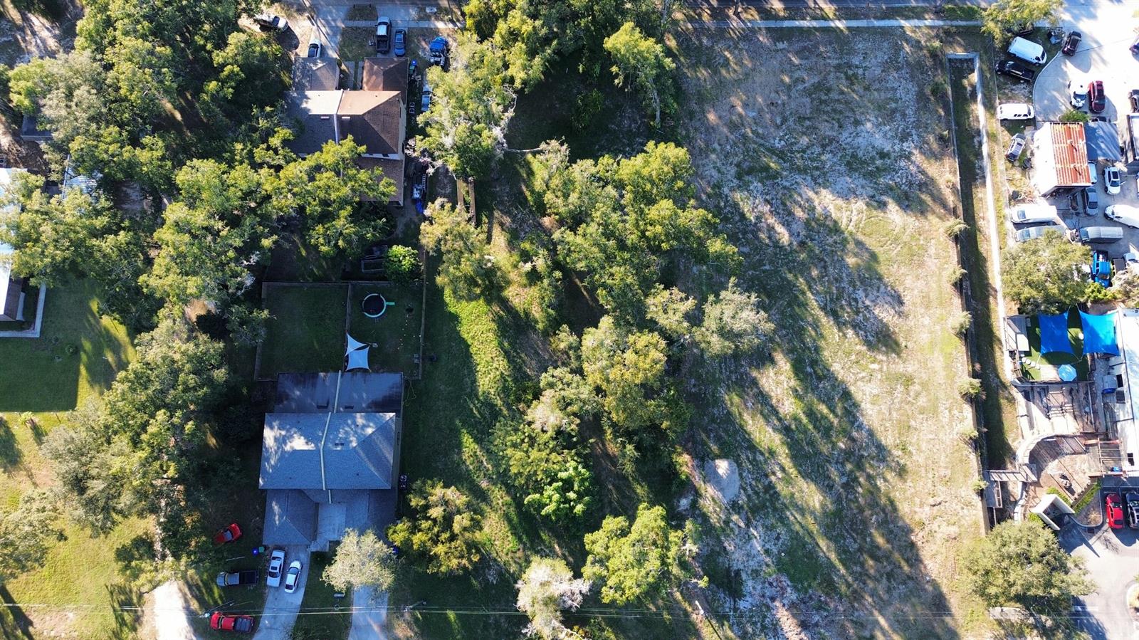 An aerial view shows a residential property with a house, trees, and an adjacent lot — 0 Sand lot #39 Avenue, FL 32703, FL
