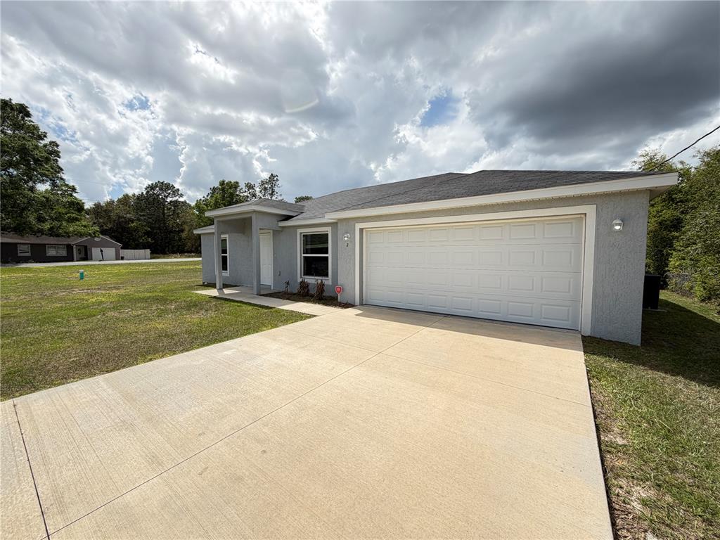 A single-story gray house with a two-car garage and a concrete driveway — 2 BAHIA COURT RUN, OCALA, FL