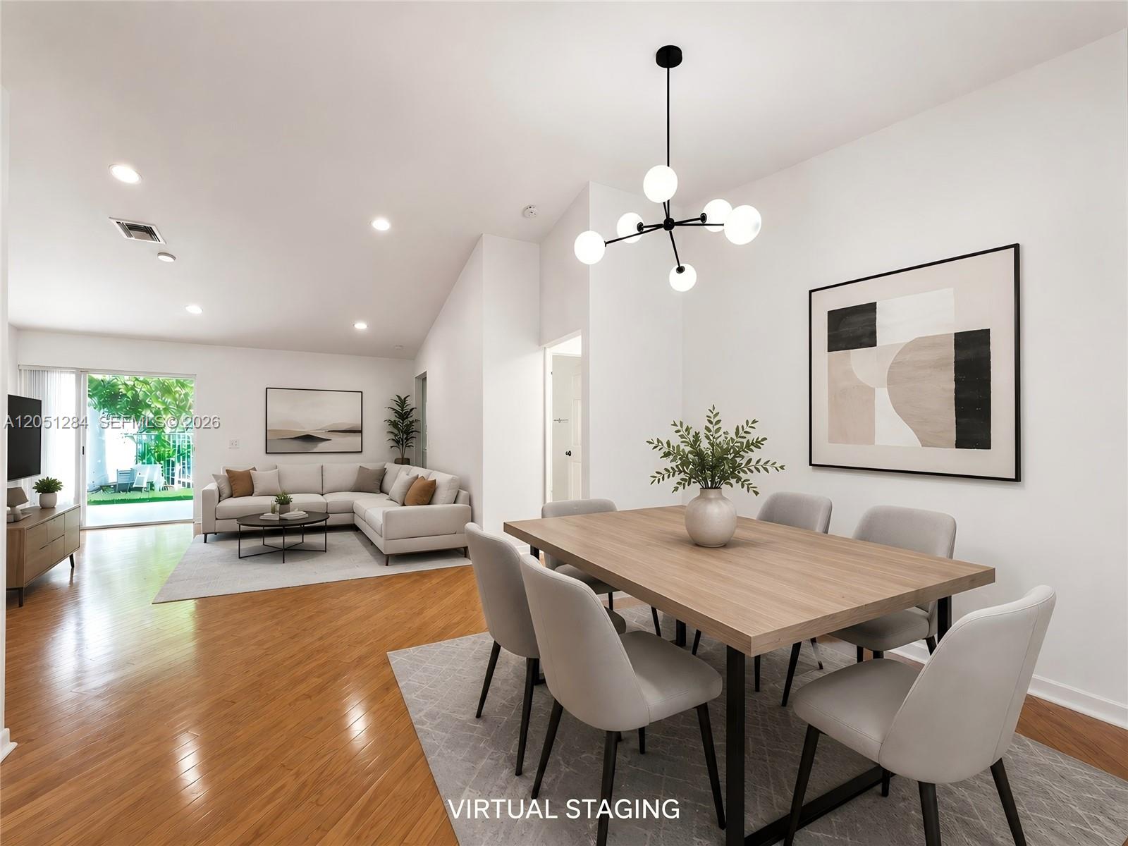 This virtually staged open-concept living and dining area features hardwood floors and modern light fixtures — 2082 Borealis Way, Weston FL 33327, WESTON, FL