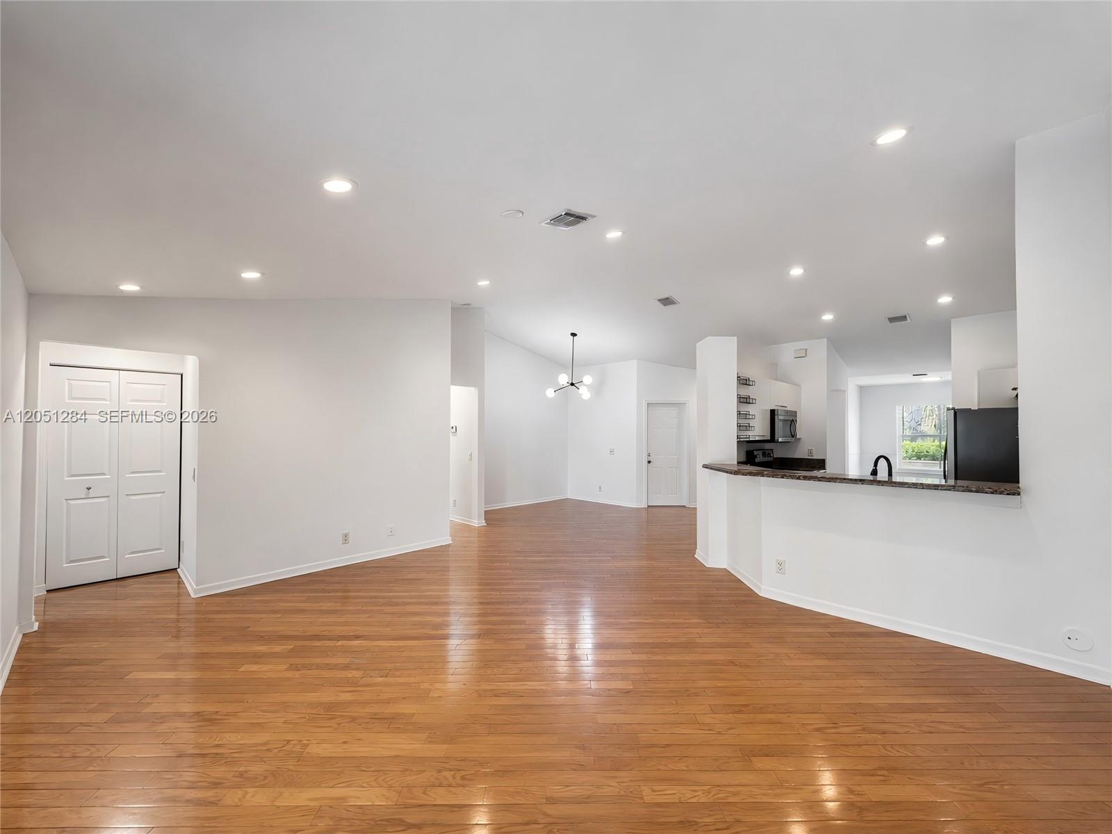 An open-concept living area features hardwood floors, recessed lighting, and a kitchen with a breakfast bar — 2082 Borealis Way, Weston FL 33327, WESTON, FL