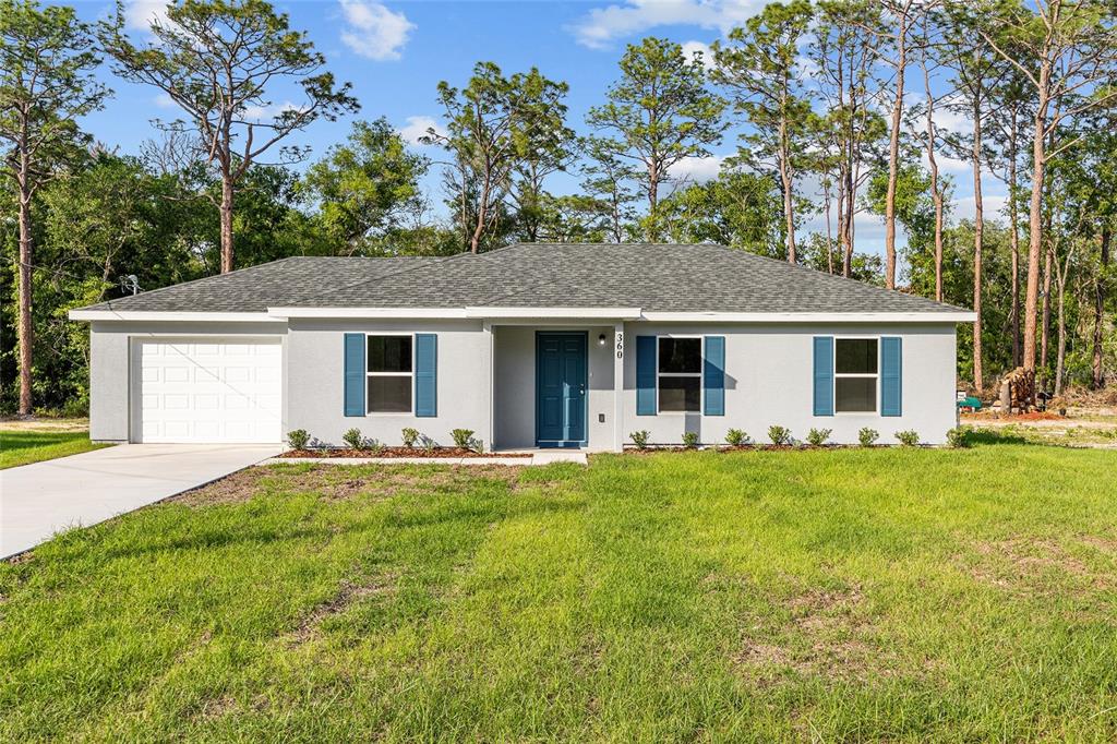 A single-story house with a white exterior, blue shutters, and a front-facing garage — 360 LOCUST ROAD, OCALA, FL