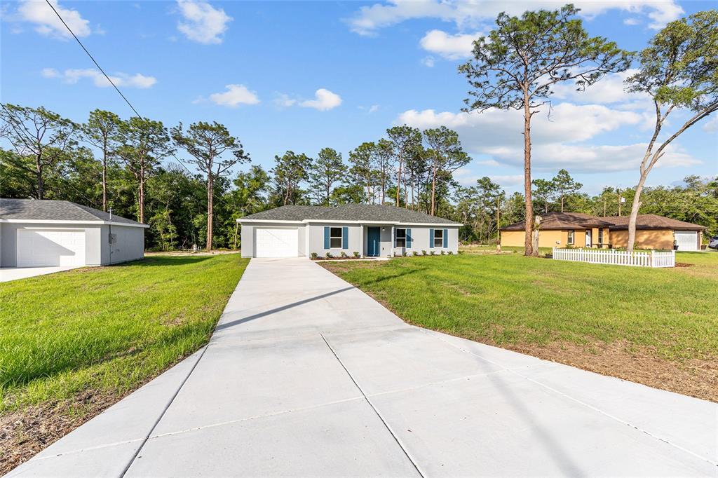 A light gray single-story house with a concrete driveway sits on a grassy lot — 360 LOCUST ROAD, OCALA, FL