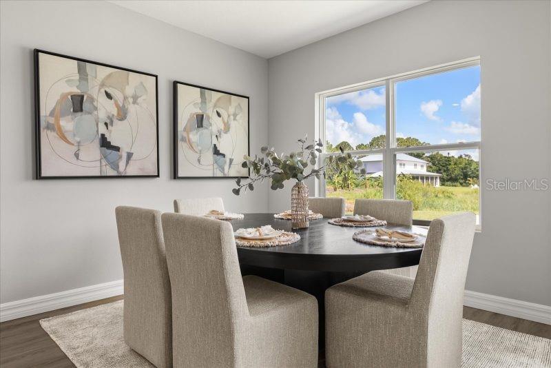 A dining room features a round black table, six upholstered chairs, and two abstract paintings — 2665 SW 162 LANE, OCALA, FL