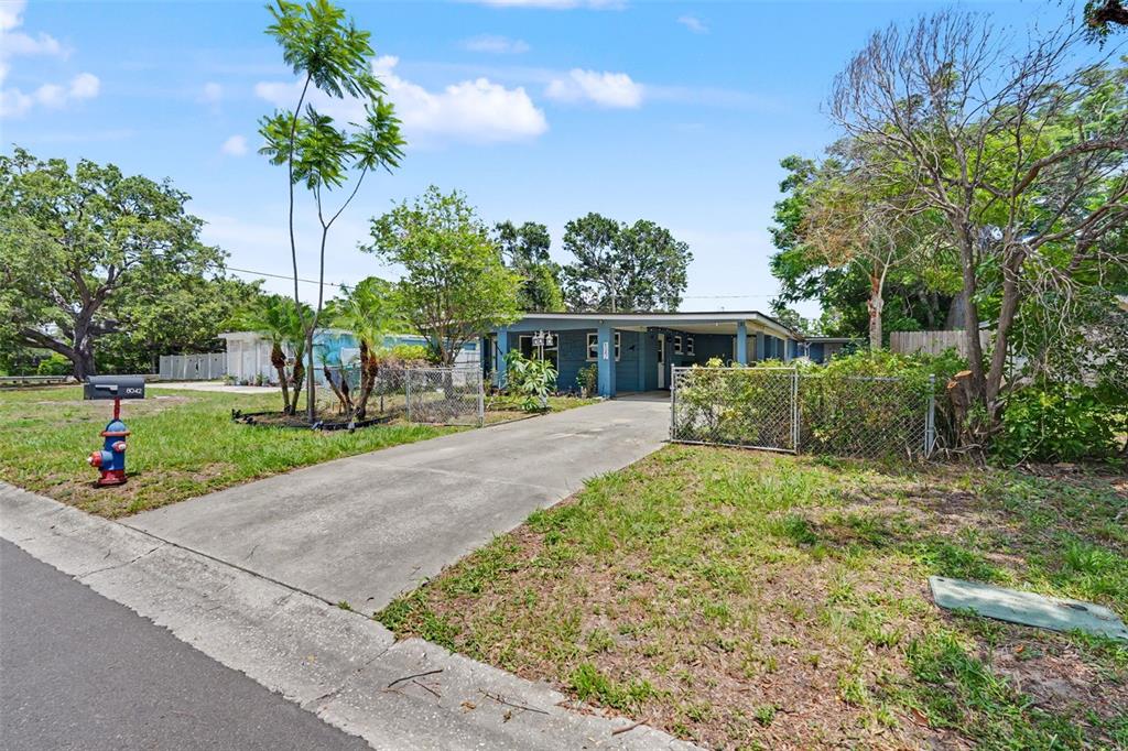 A single-story blue house with a concrete driveway and a chain-link fence — 8042 91ST TERRACE, SEMINOLE, FL