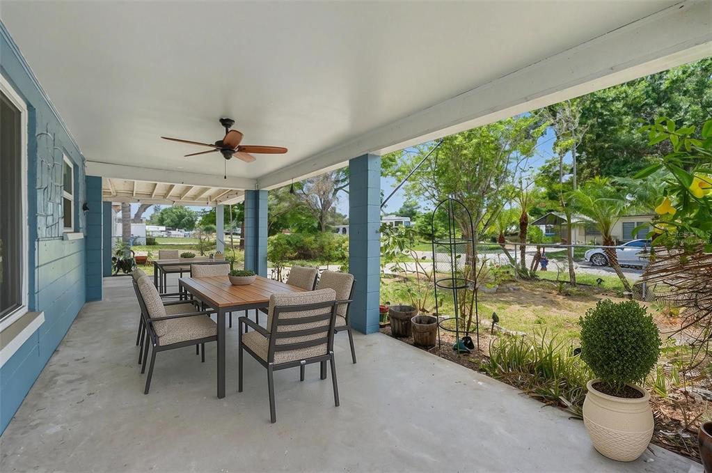 A covered outdoor patio features a dining table with chairs and a ceiling fan — 8042 91ST TERRACE, SEMINOLE, FL