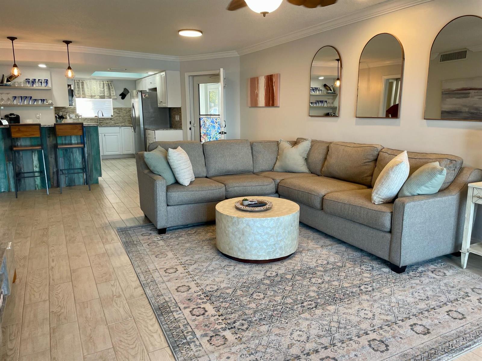 A living room with a sectional sofa, round coffee table, and an adjacent kitchen area — 410 Wilma Circle # 103, Riviera Beach FL 33404, RIVIERA BEACH, FL